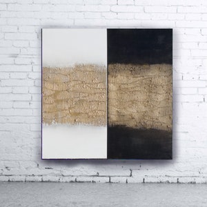 Peut inclure: &OElig;uvre d'art abstraite divis&eacute;e en deux parties : blanche et noire. Une bande textur&eacute;e dor&eacute;e traverse horizontalement le centre des deux c&ocirc;t&eacute;s. L'&oelig;uvre est accroch&eacute;e &agrave; un mur de briques blanches.