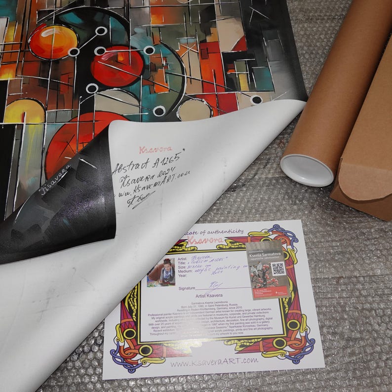 a colorful abstract painting, a certificate, and some cardboard tubes on a textured surface.