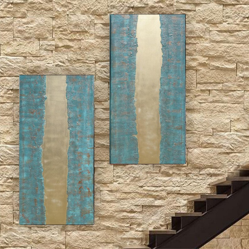 two large abstract paintings hanging on a stone wall, with a staircase visible in the background.
