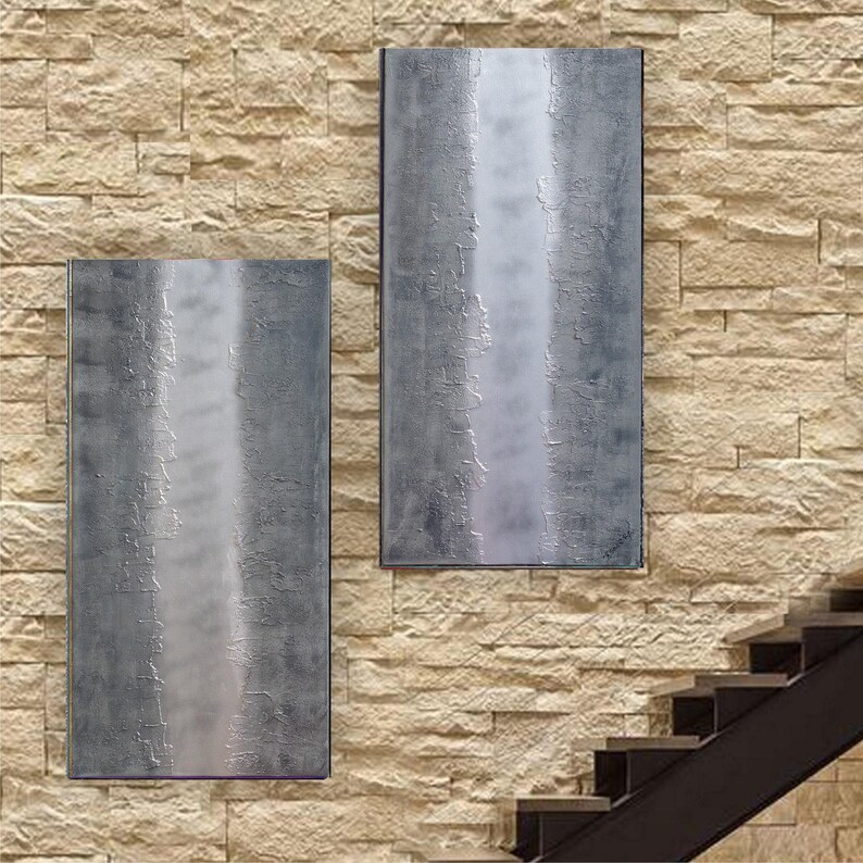 two large, rectangular metal panels mounted on a stone wall, with a staircase visible in the background.