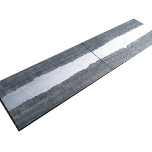 a long, rectangular, gray surface with a white line running through it, creating a sense of movement or direction.