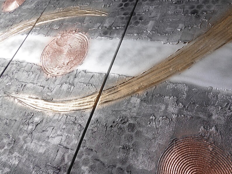 The image is a close-up of a textured surface with a metallic, metallic-looking texture. There are circular patterns and lines on the surface, creating a visually interesting and abstract design.