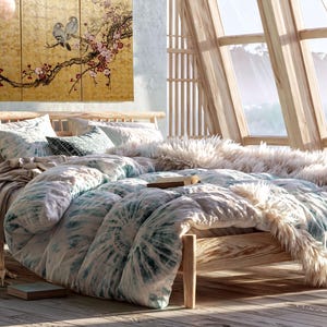 a cozy bedroom with a large bed, a wooden headboard, and a large window overlooking a scenic view. The room has a warm and inviting atmosphere, with a mix of natural and artificial elements, such as a potted plant, a vase, and a painting on the wall.