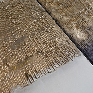 Peut inclure: &OElig;uvre d'art abstraite avec de la peinture dor&eacute;e et argent&eacute;e textur&eacute;e. L'&oelig;uvre est divis&eacute;e en sections, avec une ligne diagonale s&eacute;parant la zone textur&eacute;e dor&eacute;e d'une zone argent&eacute;e et noire. Le mot "weaved" est &eacute;crit en or.