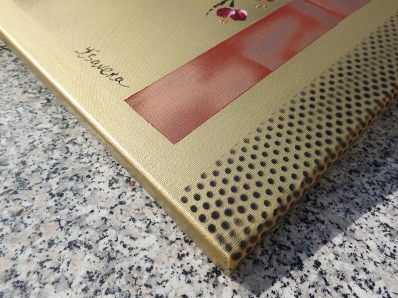 a close-up view of a gold-colored canvas with a red and black patterned texture.