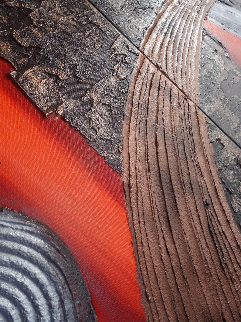 The image is a close-up of a textured surface with a combination of red, brown, and black colors. The surface appears to be a mix of different materials, such as metal and wood, with visible signs of wear and tear.