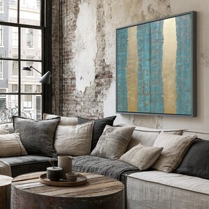 a cozy living room with a large window, a brick wall, and a wooden coffee table. The room has a mix of neutral and vibrant colors, including a blue and gold abstract painting on the wall.