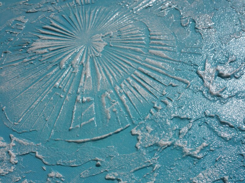 a close-up view of a textured surface with a blue-green hue, featuring a circular pattern or design created by a substance that appears to be a mixture of white and blue materials.