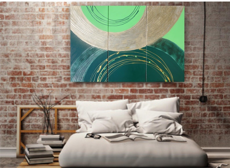 a modern bedroom with a large abstract painting hanging on the brick wall above a bed with white pillows and a white comforter.