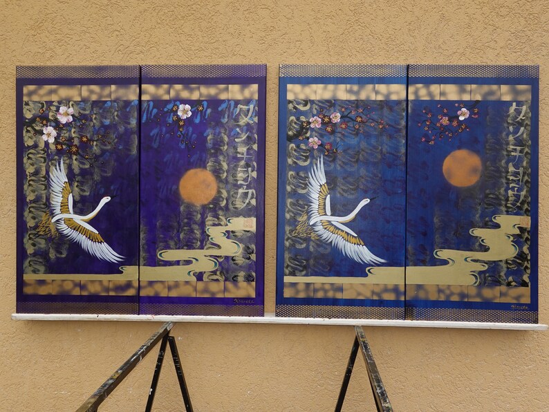 two paintings of white swans against a dark blue background, with a large orange moon and pink flowers in the center.