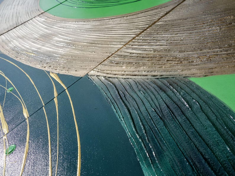 The image is a close-up view of a textured surface with a mix of green, brown, and blue colors. The surface appears to be a combination of different materials or textures, such as wood, metal, and fabric. The colors are vibrant and varied, creating a visually interesting and dynamic composition.