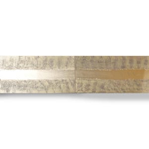 a close-up view of a metallic surface with a textured, metallic appearance. The surface appears to be made of a shiny, metallic material, possibly brass or bronze, and has a textured pattern. The image does not contain any discernible objects or actions, and there are no specific actions or movements depicted. The image does not contain any text or other objects, and it does not depict any actions or movements.