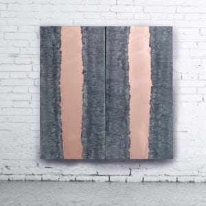 a large, abstract artwork with a striking contrast between dark and light colors. The artwork is displayed on a white brick wall, creating a visually appealing and dynamic composition.