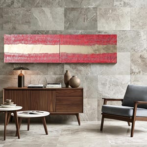 a modern living room with a large window, a wooden sideboard, a gray armchair, a wooden coffee table, and a red abstract painting on the wall.