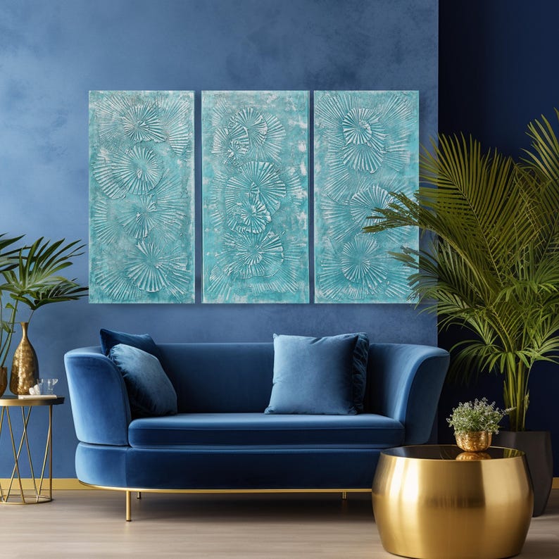a modern living room with a blue velvet sofa, a gold round coffee table, and a large blue abstract painting on the wall.