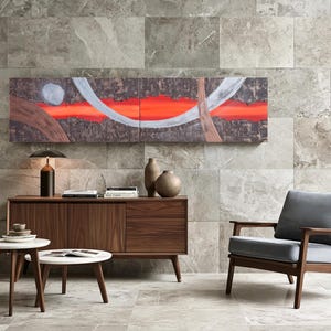 a modern living room with a large abstract painting on the wall, a wooden sideboard with a lamp and decorative items, a gray armchair, and a round coffee table.
