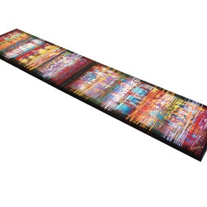 The image is a long, horizontal painting with a vibrant, colorful abstract design. The painting features a variety of colors and brushstrokes, creating a dynamic and visually striking composition.
