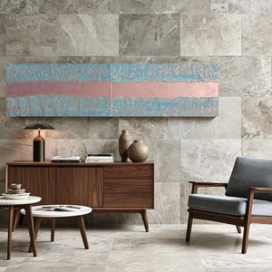 a modern living room with a wooden cabinet, a gray armchair, a round coffee table, and a large abstract painting on the wall.