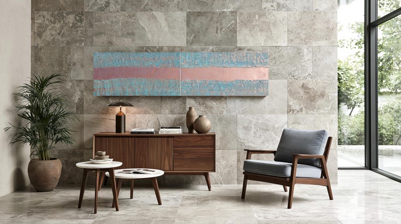 a modern living room with a wooden cabinet, a gray armchair, a round coffee table, and a large abstract painting on the wall.