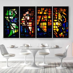 a modern dining room with a white table and chairs, and a large, colorful stained glass window above the table.