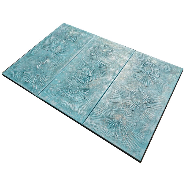 a blue tile with a repeating pattern of white and green designs, including a floral pattern and a fan-like design.