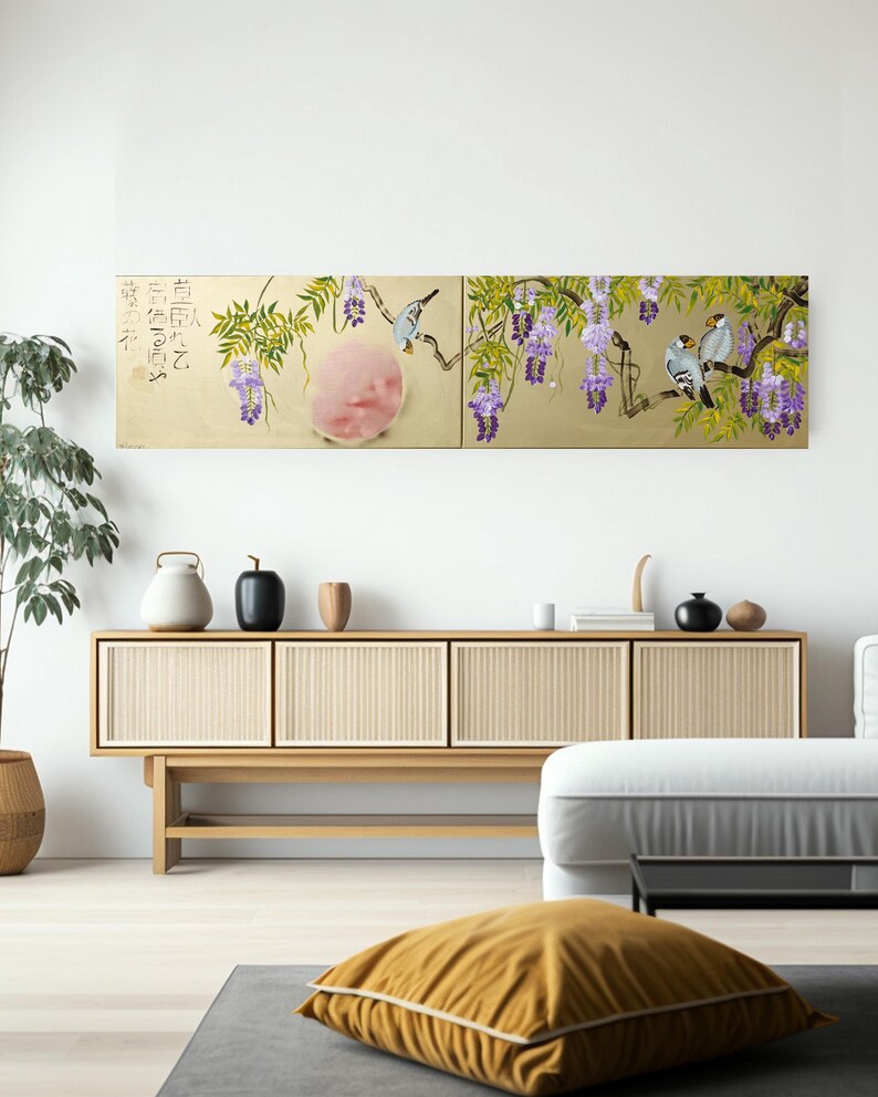a modern living room with a large, colorful painting of a bird perched on a branch with purple flowers hanging on the wall above a wooden cabinet. The cabinet has a glass front and is adorned with various decorative items such as vases and a teapot. The room also includes a comfortable couch and a potted plant, creating a cozy and inviting atmosphere.