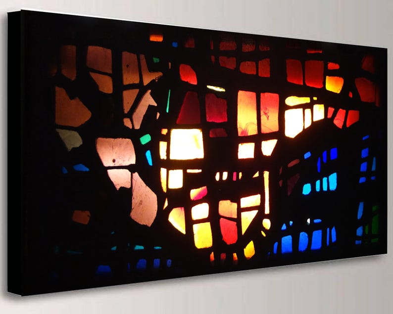 The image is a vibrant, abstract stained glass artwork with a colorful, geometric pattern of shapes and colors.