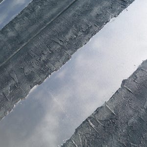 a close-up view of a textured surface with a metallic sheen, featuring a diagonal line running through it.