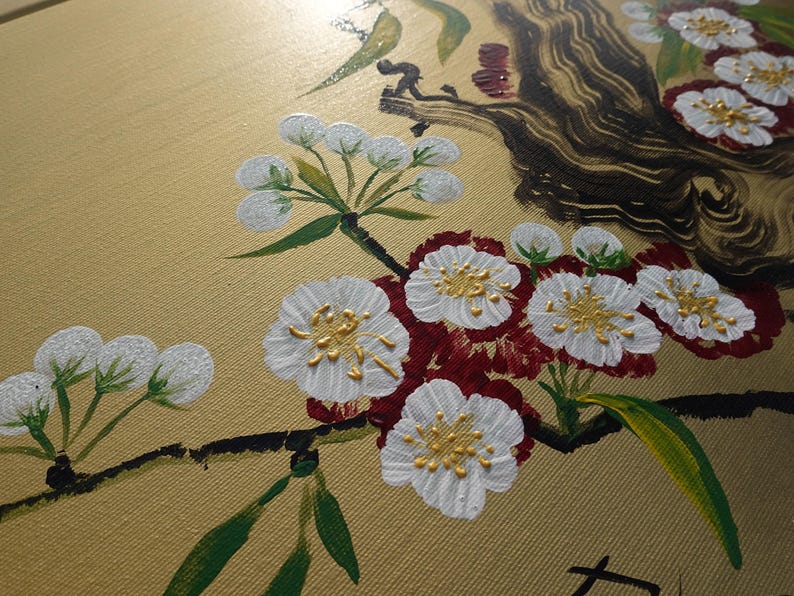 a close-up view of a painting depicting a branch with white flowers and green leaves.
