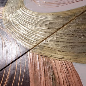 The image is a close-up of a textured surface with a metallic, textured appearance. The surface has a combination of brown, white, and gray colors, with a metallic sheen that gives it a unique and visually interesting look.