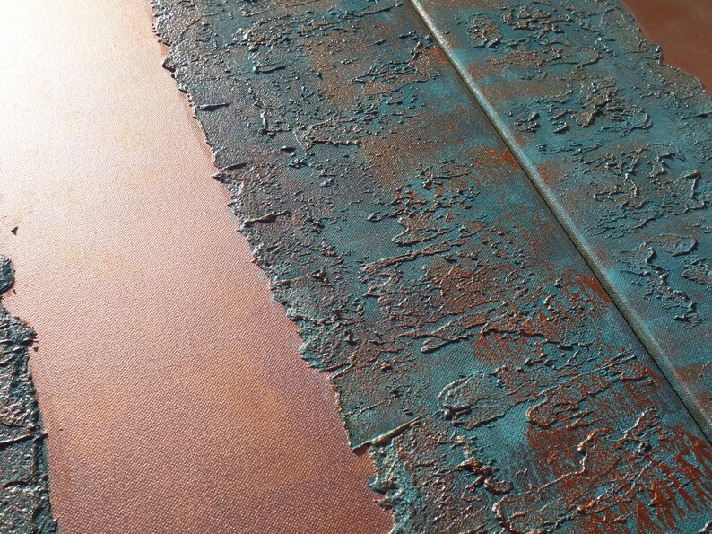 a close-up view of a textured surface with a metallic sheen, featuring a combination of blue and orange colors. The surface appears to be a mix of paint or material with a rough, uneven texture, giving it a somewhat distressed or aged appearance.