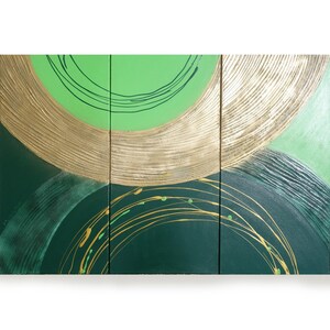 The image is a triptych of abstract paintings, featuring a combination of green and gold colors. The paintings are arranged in a grid format, with each panel showcasing a unique design. The overall composition is visually striking and captures the viewer's attention.
