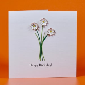 Charms marguerites Carte d'anniversaire avec trois charms marguerites en émail qui peuvent être réutilisés comme bijoux.