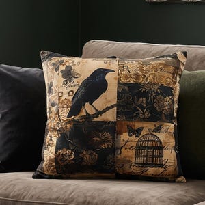 May include: A square scatter cushion featuring a patchwork design in shades of black, tan, and brown. The print includes a black crow perched on a branch, a birdcage, butterflies, floral patterns, and script text layered over a vintage-style background.