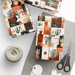 May include: Gift-wrapped presents with a patchwork design featuring cacti and succulents in terracotta, cream, and dark green squares. Each package is tied with twine and a white star or heart-shaped tag. A ball of twine, scissors, and blank tags are also visible.