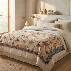 Manta decorativa de algodón tejido con motivos botánicos y flecos, elegante diseño floral de estilo clásico, ideal para la decoración del hogar en un entorno campestre francés o rústico.
