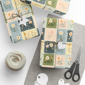 May include: Gift-wrapped presents with floral patterned paper in pastel colors. Each package is tied with twine and a white tag. A ball of twine, scissors, and blank tags are also visible, suggesting a crafting or gift-giving theme.