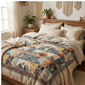 Può includere: Un letto con una trapunta patchwork con un design ispirato alla natura. La trapunta presenta quadrati con motivi montani, floreali e astratti nei toni del blu, dell'oro e del marrone. Il letto è fatto con lenzuola e cuscini dai colori neutri.