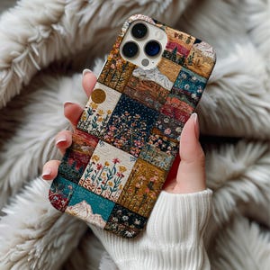 Könnte beinhalten: Eine bunte Handyhülle mit Patchwork-Design. Die Hülle zeigt Blumen-, Berg- und Landschaftsmuster in einer Vielzahl von Farben, darunter Türkis, Braun und Gold. Die Hülle wird in einer Hand gehalten.