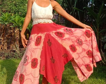 May include: A red and pink tie-dye skirt with a floral print. The skirt is asymmetrical and has a long, flowing design.