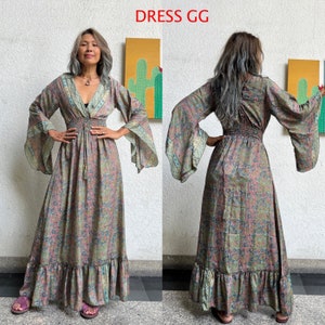 May include: A long, flowing maxi dress with a floral print in shades of green, pink, and blue. The dress has a V-neckline, long sleeves with bell cuffs, and a fitted waist with a drawstring. The dress has a tiered ruffle hem.