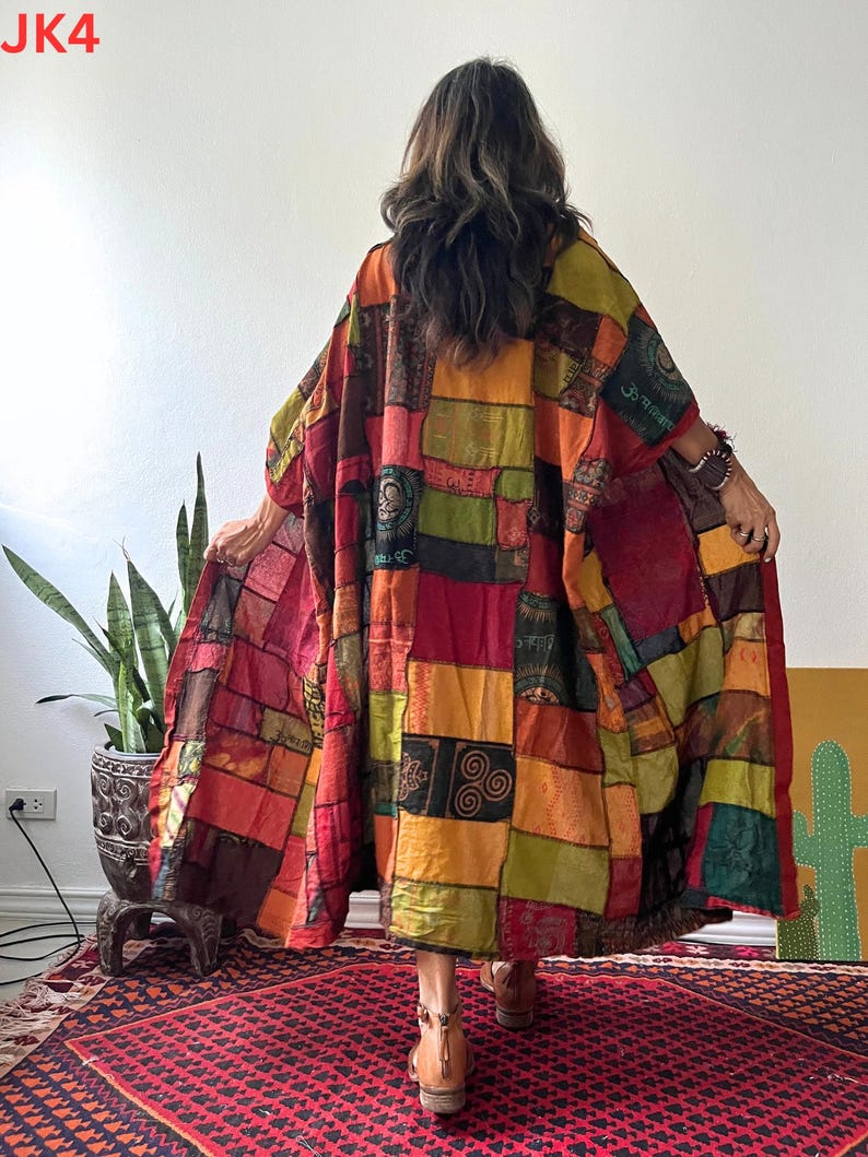 May include: A long, loose-fitting kimono-style robe featuring a patchwork design of various rectangular fabric panels in shades of red, orange, yellow, olive green, and brown, with printed symbols and patterns throughout and the text JK4.