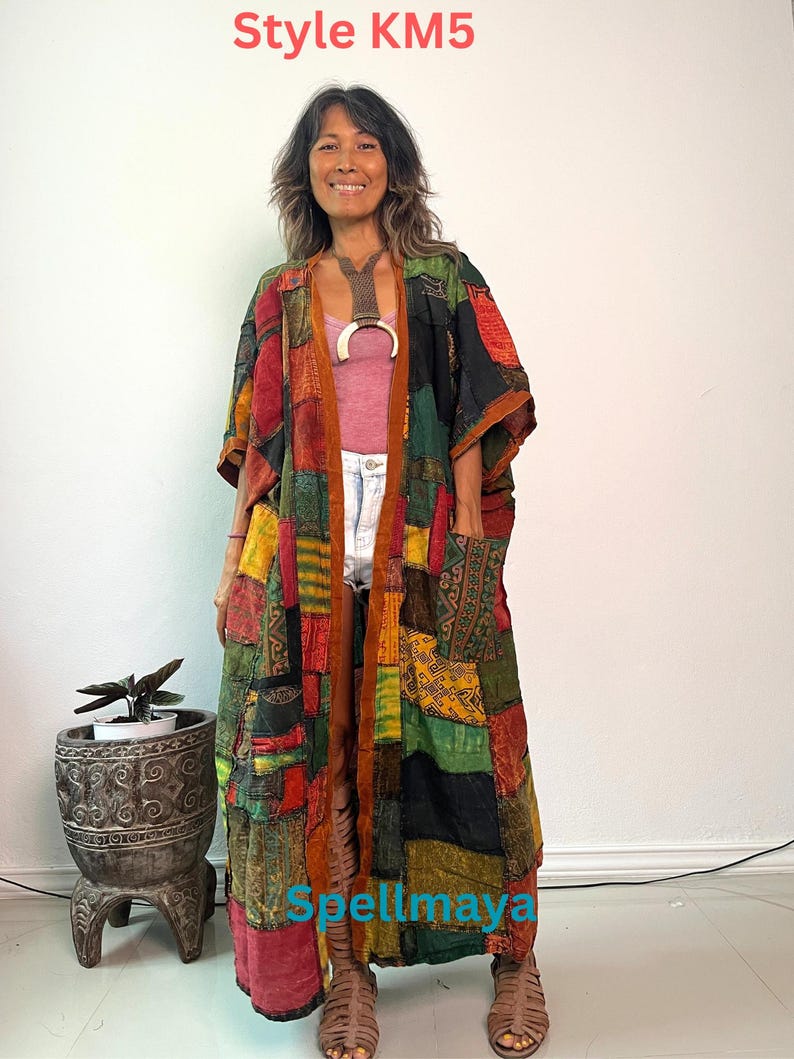 May include: A long, open-front kimono featuring a patchwork design with various rectangular fabric panels in shades of red, green, yellow, and black. The garment includes two front pockets and a brown trim. Text reads Style KM5 and Spellmaya.