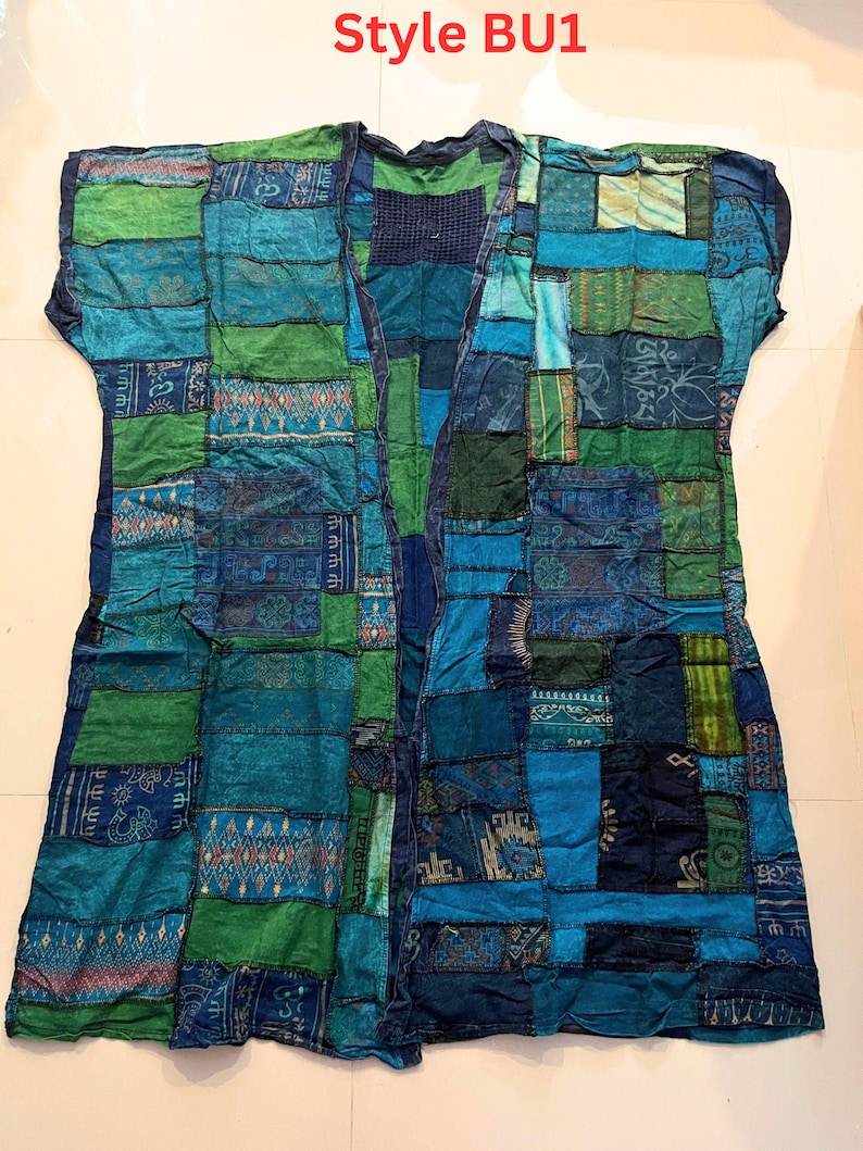 May include: A sleeveless open-front vest featuring a patchwork design composed of various blue and green fabric squares. The garment displays diverse patterns, including geometric shapes and floral motifs, with the text Style BU1 at the top.
