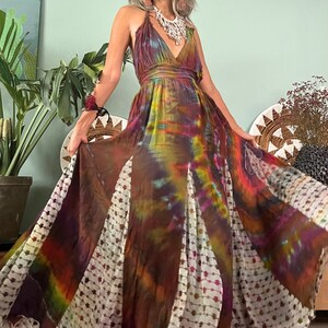 Pode incluir: Um vestido maxi longo e fluido com estampa tie-dye, decote em V e acabamento branco. O vestido &eacute; feito de um tecido macio e fluido e tem um caimento solto.