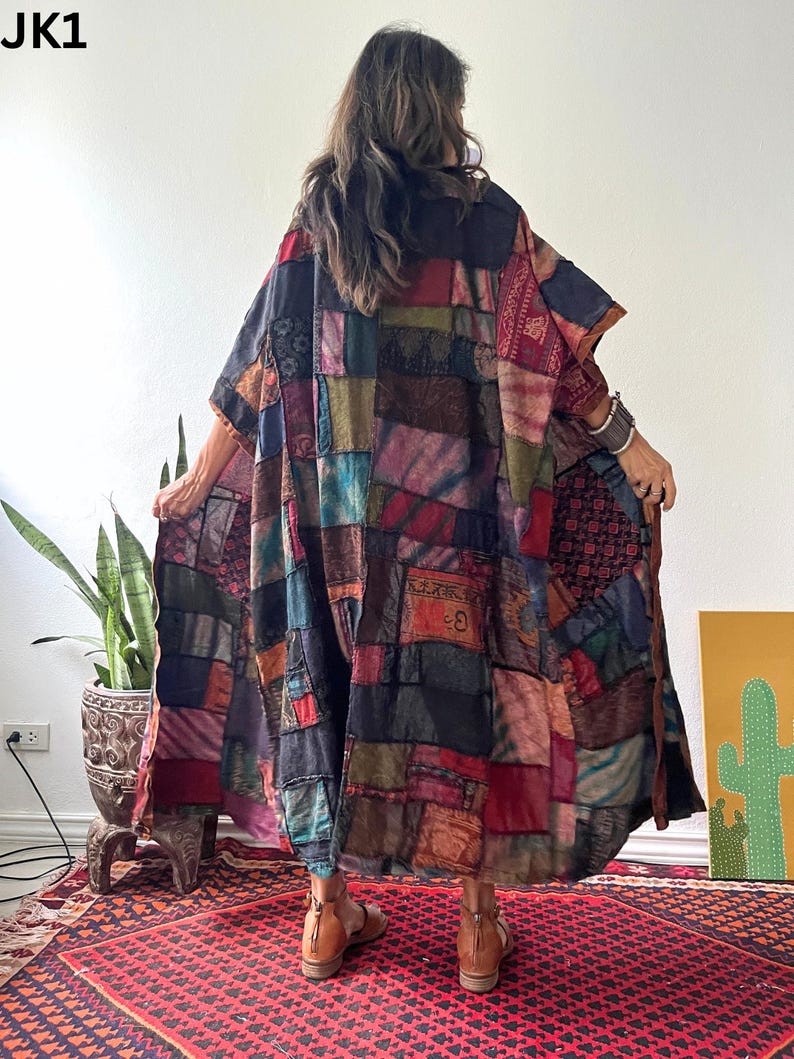 May include: A long, loose-fitting kimono-style garment featuring a patchwork design composed of various rectangular fabric panels in shades of red, blue, black, green, and brown. The garment displays diverse textures and patterns throughout.