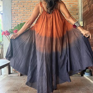May include: A flowing, sleeveless dress with a gradient color scheme, transitioning from orange at the top to dark gray at the hem. The dress features a wide, flared skirt and a textured bodice. The text "Dress D4" is visible in the upper left corner.