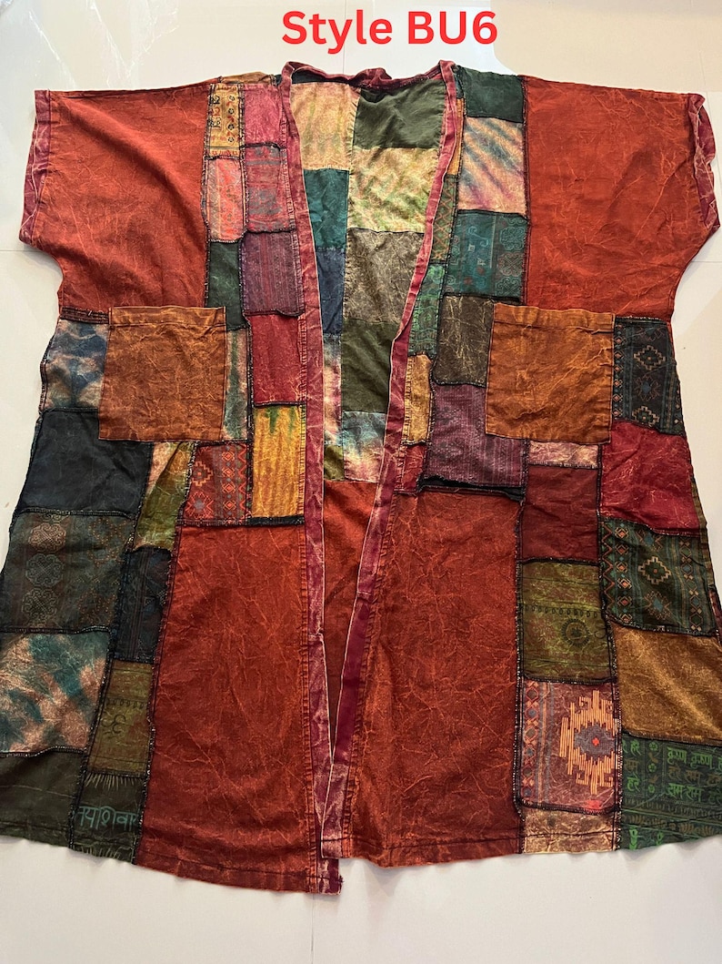 May include: A patchwork kimono-style jacket featuring the text Style BU6 at the top. The garment is constructed from various fabric squares in shades of rust, olive green, deep blue, and gold, with two large front pockets and short sleeves.