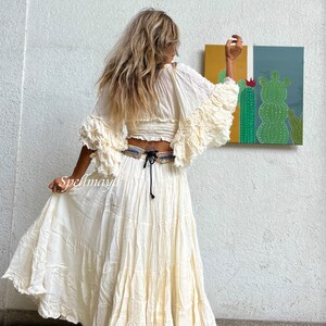 May include: A white, flowy maxi skirt with a ruffled hem. The skirt is made of a lightweight fabric and has a drawstring waist.