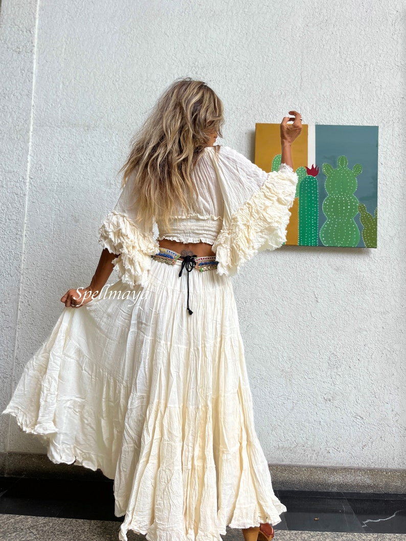 May include: A white, flowy maxi skirt with a ruffled hem. The skirt is made of a lightweight fabric and has a drawstring waist.